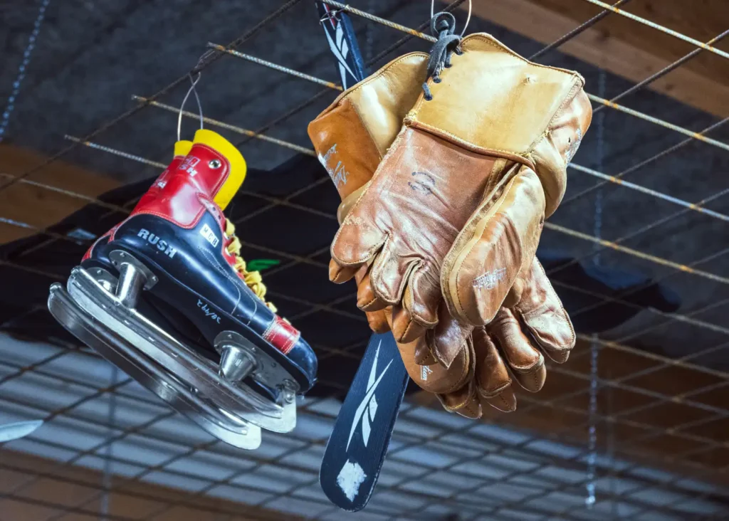 2023-02-25-Fritidsbanken-Enkoping-4 - RIM Digital Ett par gamla skridskor och hockeyhandskar hängandes i taket på Fritidsnanken i Enköping.